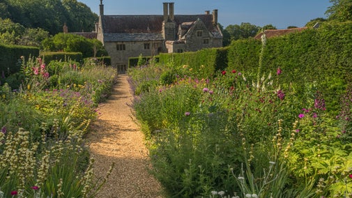 Colourful double flower borders looking down to Manor House